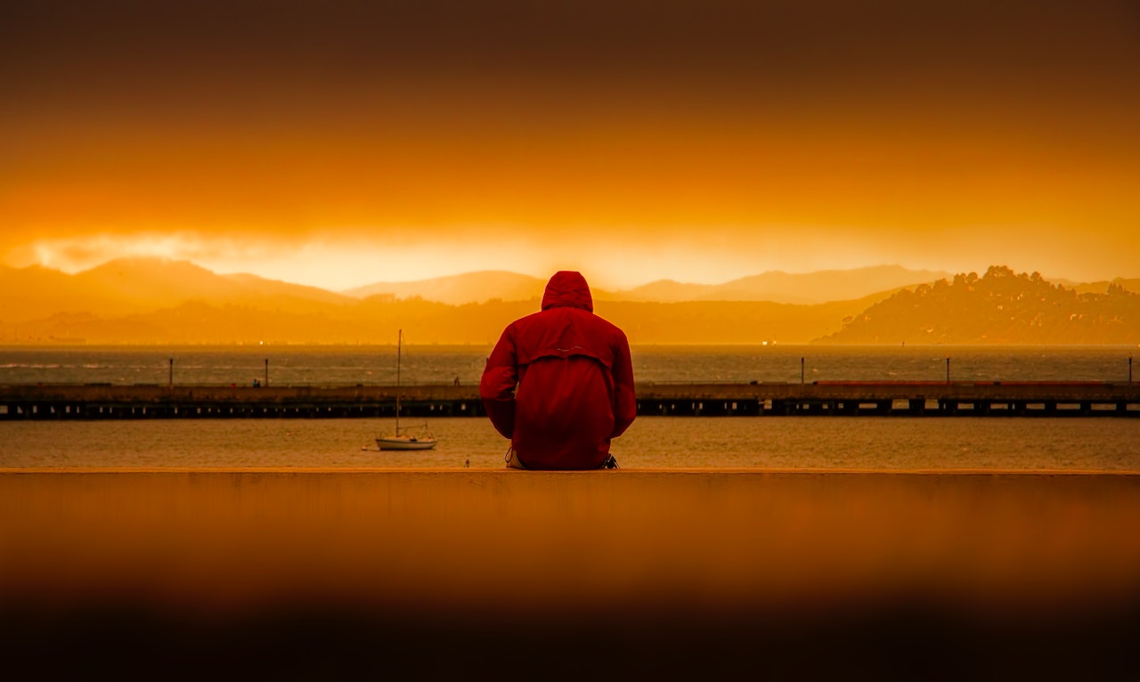 Foto de Quintin Gellar: https://www.pexels.com/es-es/foto/persona-vestida-con-sudadera-roja-sentada-delante-del-cuerpo-de-agua-636164/