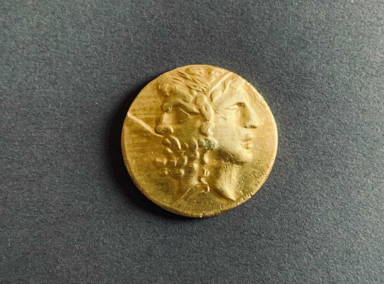Foto de Lydia Griva: https://www.pexels.com/es-es/foto/moneda-de-oro-antigua-sobre-fondo-oscuro-30123614/
