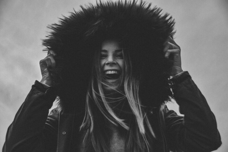 Foto de Stephan Seeber: https://www.pexels.com/es-es/foto/foto-en-escala-de-grises-de-mujer-riendo-sosteniendo-su-sombrero-1054251/